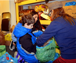 Eden, Sam & Mom, Jami re-bagging cat food at Jesus Focus Ministry Food Pantry